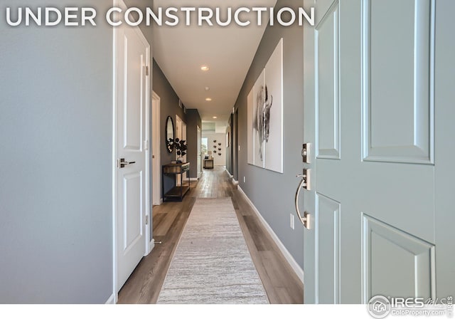 hall featuring recessed lighting, wood finished floors, and baseboards