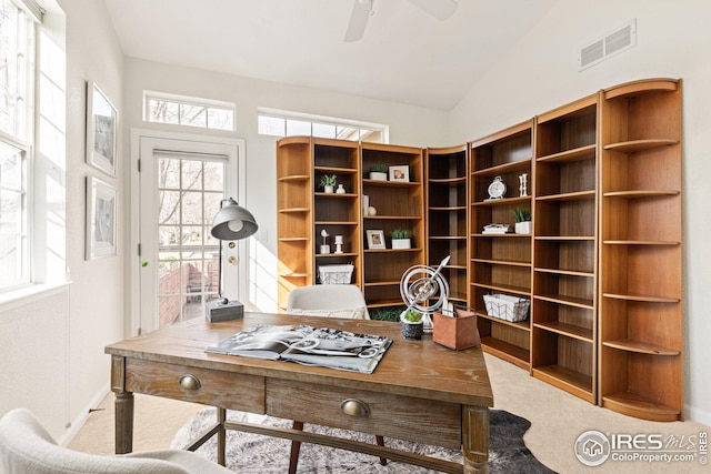 carpeted office space featuring visible vents, a ceiling fan, and vaulted ceiling