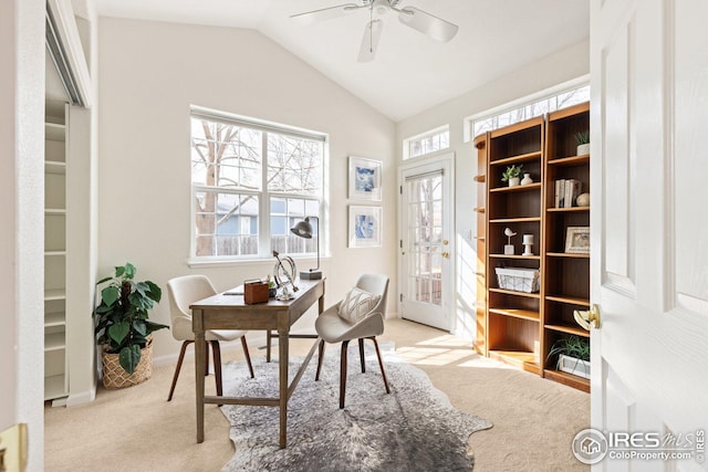 office area featuring baseboards, lofted ceiling, light carpet, and a ceiling fan