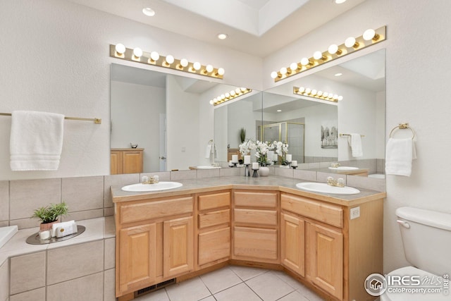 bathroom with a shower stall, toilet, visible vents, and a sink