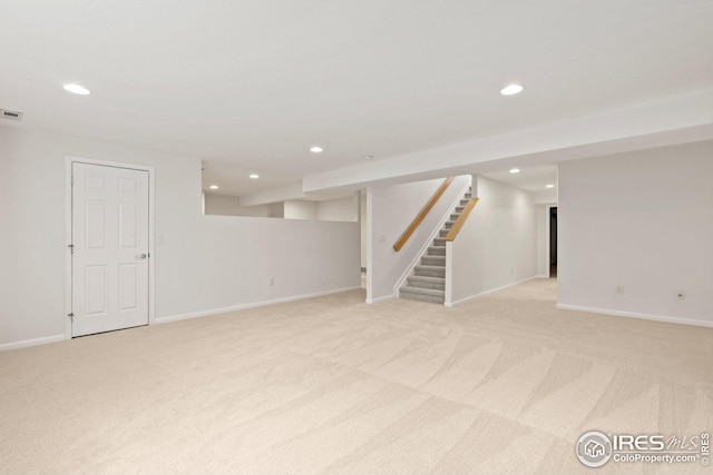 finished below grade area featuring recessed lighting, stairway, and light colored carpet