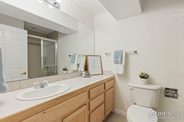 full bath with tile patterned floors, toilet, a stall shower, and vanity