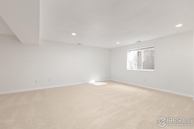 unfurnished room with recessed lighting, baseboards, and light carpet