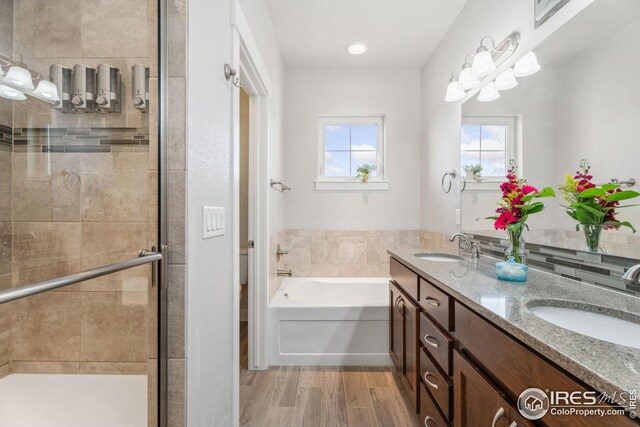 2556 Des Moines Dr Unit 103, Fort Collins, CO 80525 - bathroom featuring a sink, wood finished floors, a stall shower, and a bath