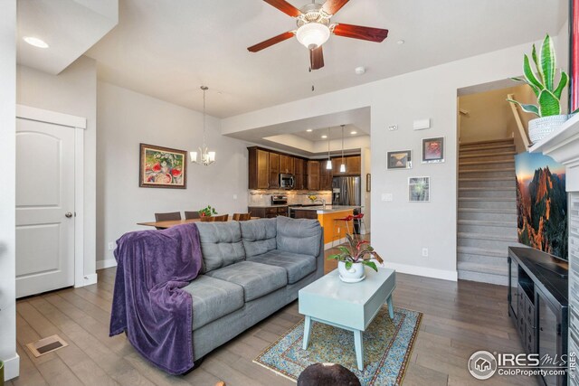 2556 Des Moines Dr Unit 103, Fort Collins, CO 80525 - living area featuring baseboards, stairs, ceiling fan with notable chandelier, wood finished floors, and a raised ceiling