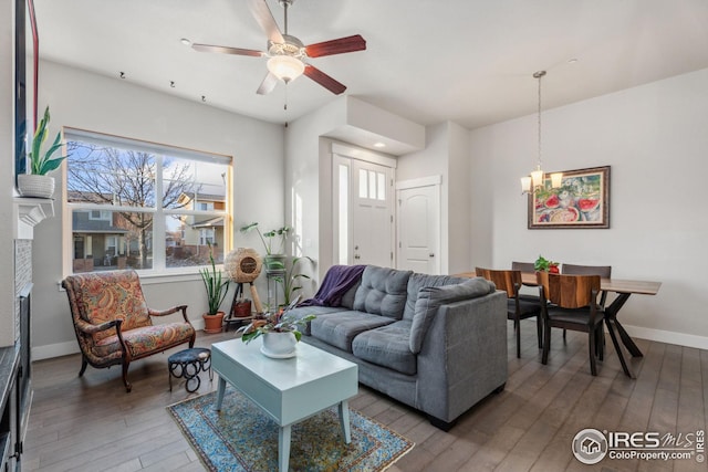 2556 Des Moines Dr Unit 103, Fort Collins, CO 80525 - living room featuring baseboards, plenty of natural light, ceiling fan with notable chandelier, and hardwood / wood-style flooring