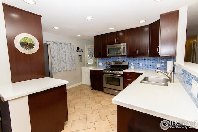 kitchen featuring tasteful backsplash, light countertops, recessed lighting, appliances with stainless steel finishes, and a sink