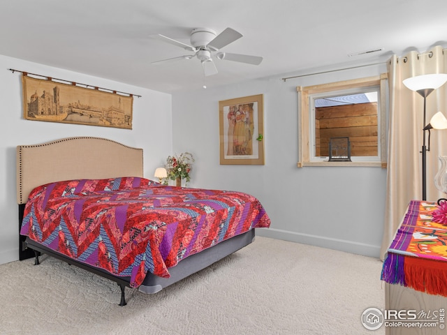 carpeted bedroom with a ceiling fan, visible vents, and baseboards