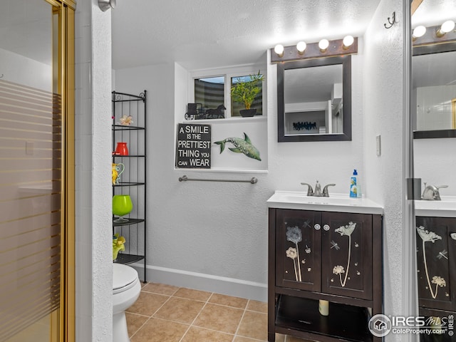 full bath with baseboards, toilet, vanity, tile patterned floors, and a textured ceiling