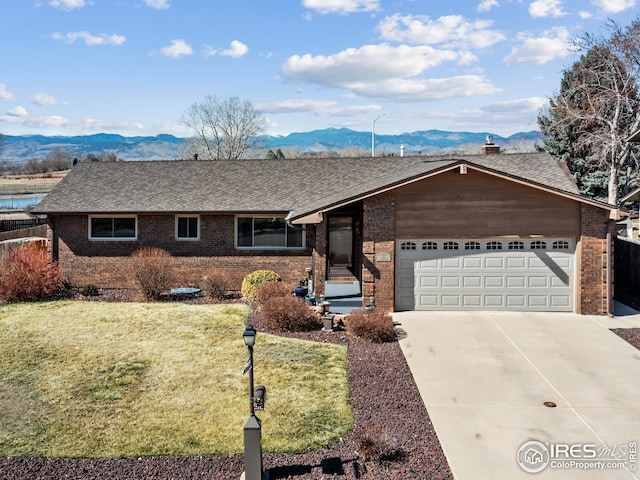 ranch-style home with brick siding, a mountain view, and driveway