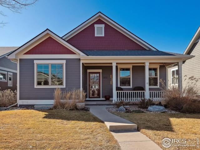 view of front of house featuring covered porch and a front lawn