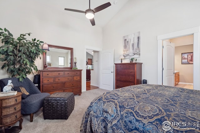 bedroom with ensuite bath, high vaulted ceiling, carpet, and a ceiling fan