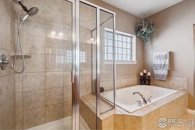 bathroom with a bath and a stall shower