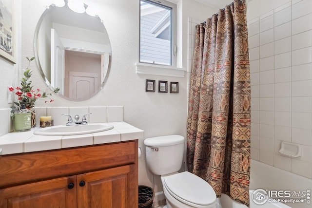 bathroom featuring shower / bath combination with curtain, toilet, and vanity