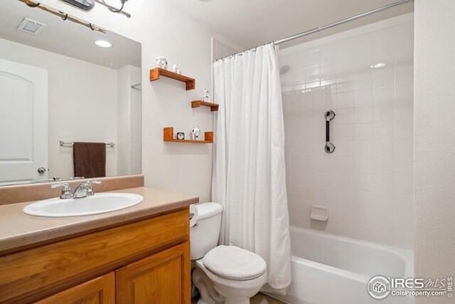 full bathroom with visible vents, vanity, toilet, and shower / tub combo with curtain