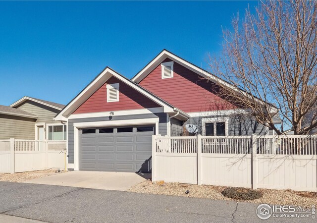view of front of house with fence, a garage, and driveway