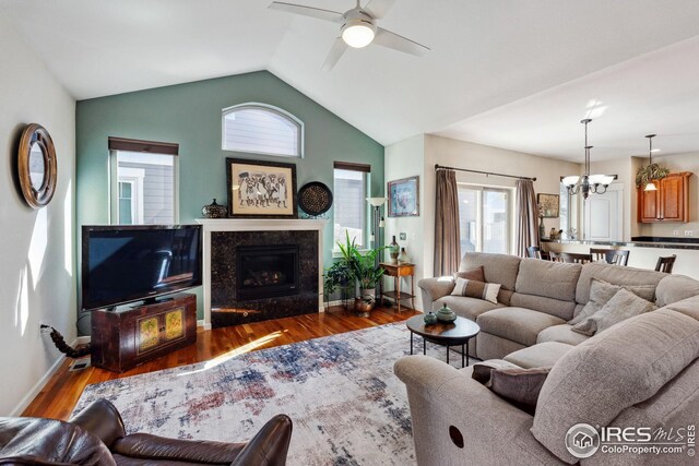 living area with plenty of natural light, wood finished floors, and vaulted ceiling