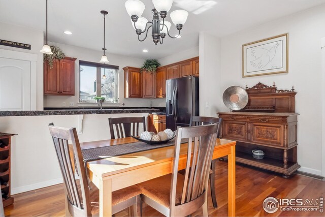 dining room featuring recessed lighting, light wood-type flooring, baseboards, and an inviting chandelier