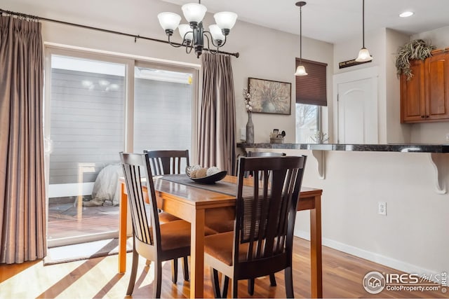 dining room with light wood-style flooring, recessed lighting, baseboards, and a chandelier