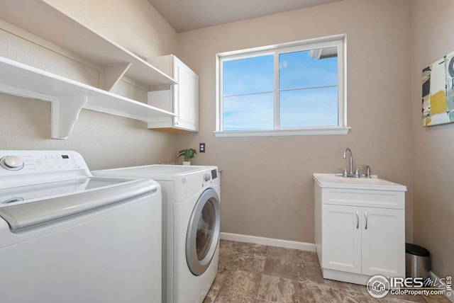 laundry room with baseboards, cabinet space, washer and clothes dryer, and a sink