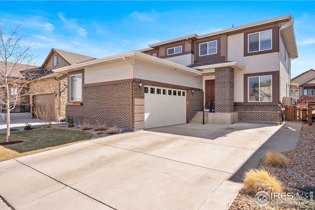 view of front of home with brick siding, fence, and driveway