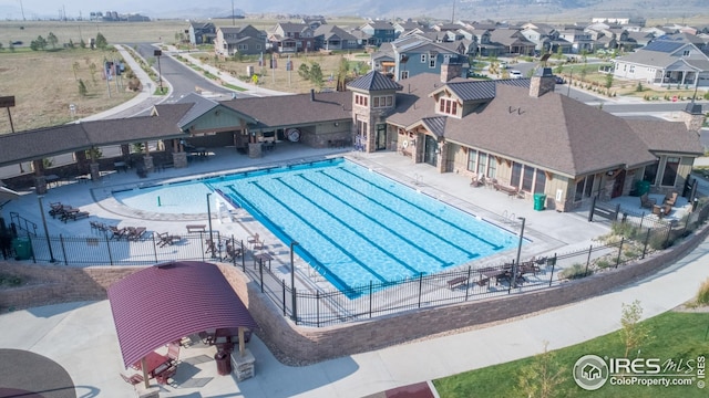pool featuring a patio, fence, and a residential view