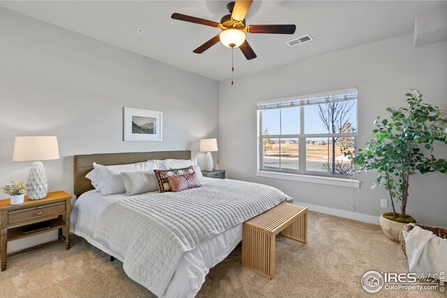 carpeted bedroom with a ceiling fan, baseboards, and visible vents
