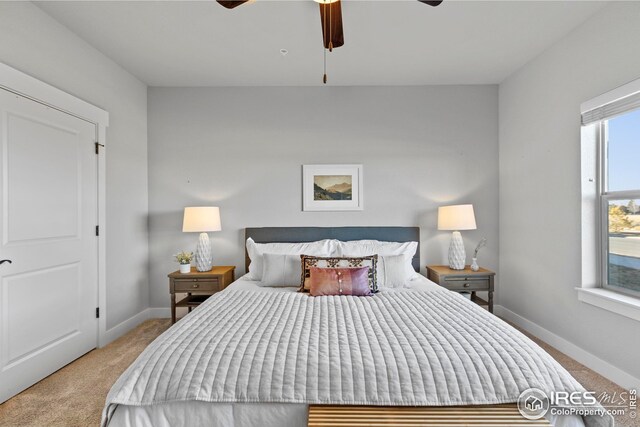bedroom featuring light carpet, ceiling fan, and baseboards