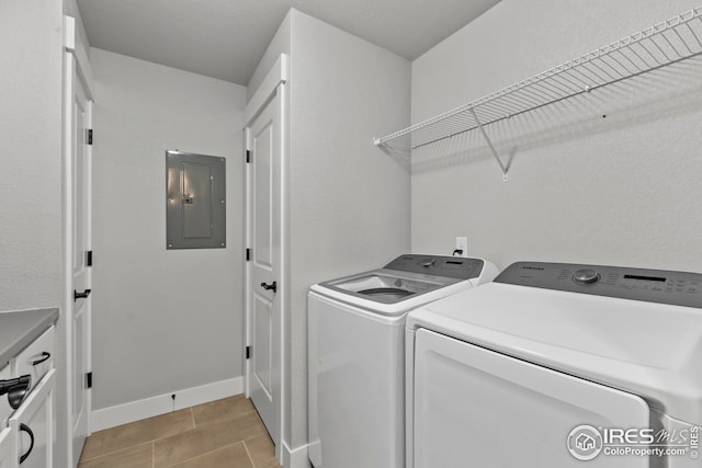 clothes washing area featuring electric panel, laundry area, baseboards, and separate washer and dryer