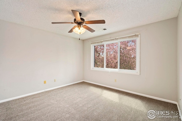unfurnished room with carpet flooring, a ceiling fan, visible vents, and a textured ceiling