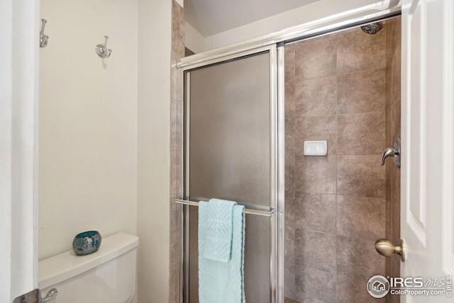 bathroom with vanity, tile patterned floors, toilet, a stall shower, and a textured ceiling