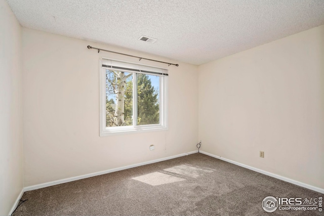 unfurnished room featuring a textured ceiling, visible vents, carpet floors, and baseboards