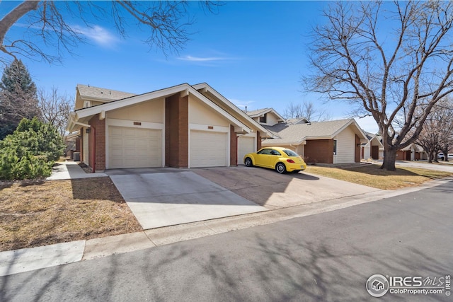 view of front of house featuring a garage, brick siding, and concrete driveway