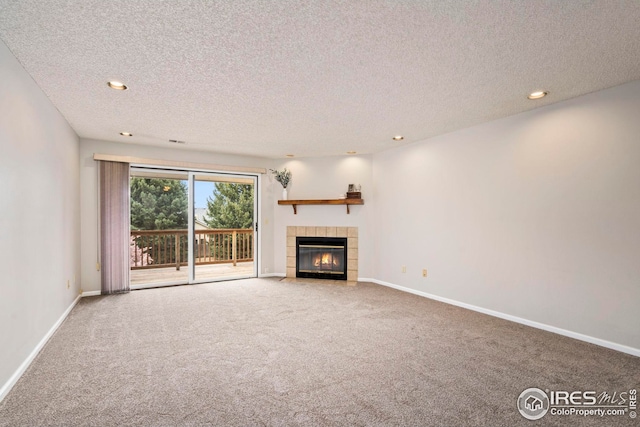 unfurnished living room with baseboards, a fireplace, a textured ceiling, and carpet
