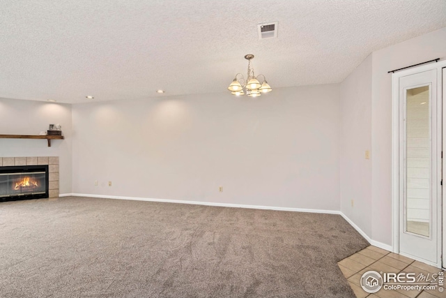 living area with a textured ceiling, carpet flooring, visible vents, baseboards, and a notable chandelier