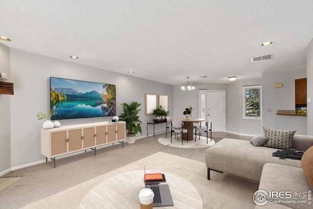 living room with a chandelier, visible vents, baseboards, a textured ceiling, and carpet floors
