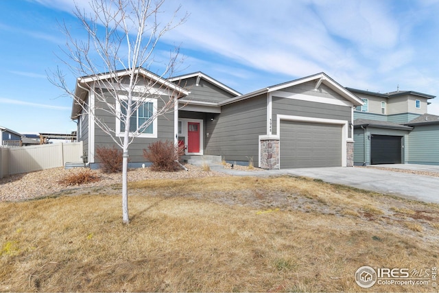 craftsman-style home featuring concrete driveway, fence, a garage, and a front yard