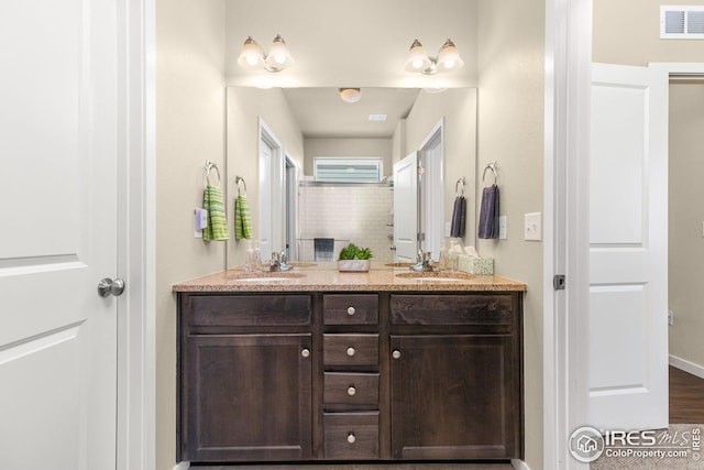 full bathroom featuring double vanity, visible vents, a shower, and a sink