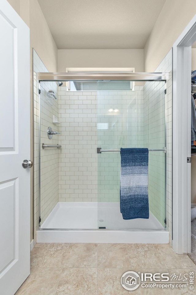 bathroom with tile patterned floors and a shower stall