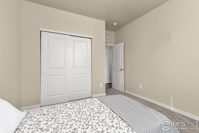 carpeted bedroom with visible vents, baseboards, and a closet