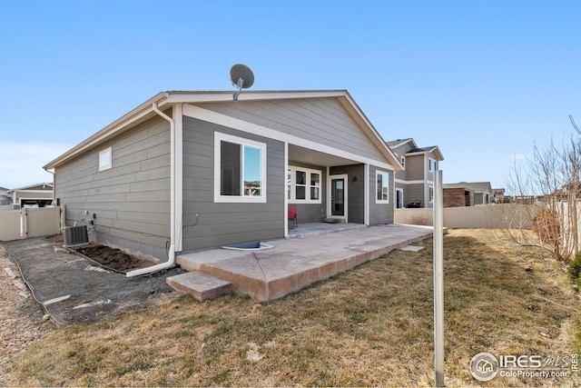 back of house with central AC unit, a yard, a patio area, and fence