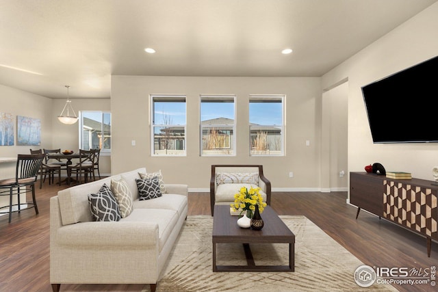 living area with recessed lighting, wood finished floors, and baseboards