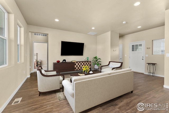 living area with recessed lighting, visible vents, and dark wood finished floors