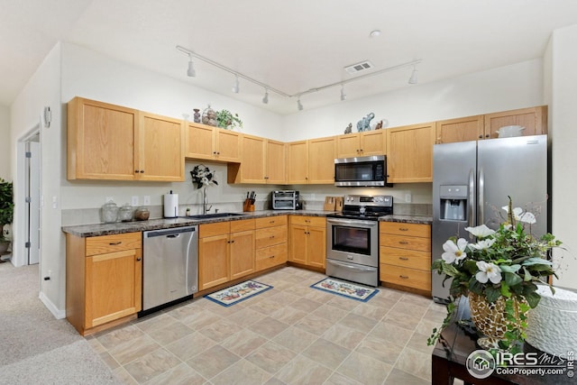 kitchen with visible vents, a toaster, a sink, light brown cabinetry, and stainless steel appliances