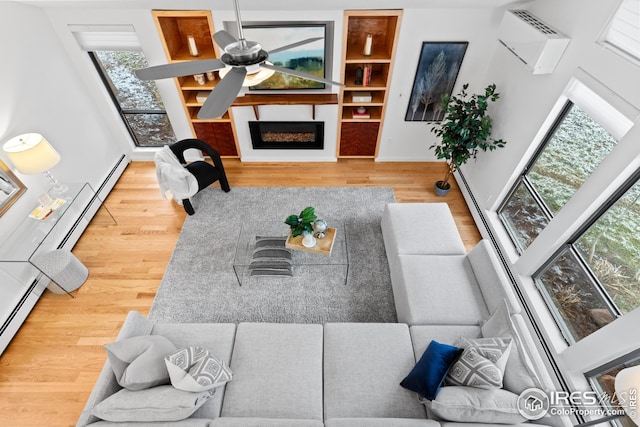 living room with a fireplace, baseboards, a ceiling fan, and wood finished floors