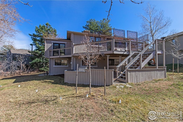 back of property with a lawn, stairs, and a deck