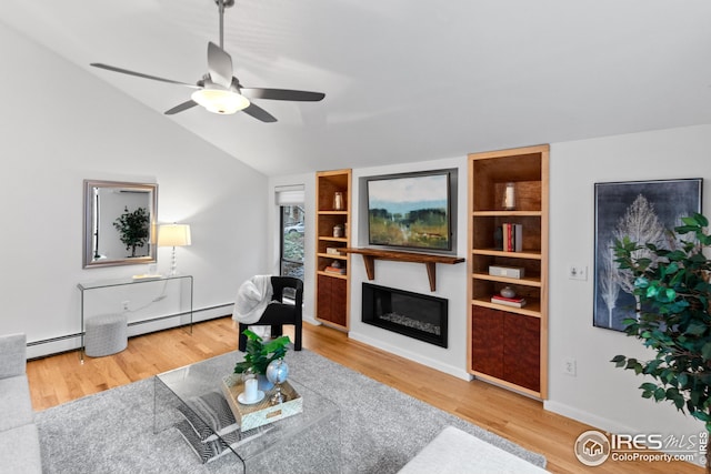 living area featuring baseboard heating, wood finished floors, lofted ceiling, and a glass covered fireplace