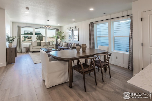 dining room featuring recessed lighting, a notable chandelier, light wood-style floors, and a textured ceiling