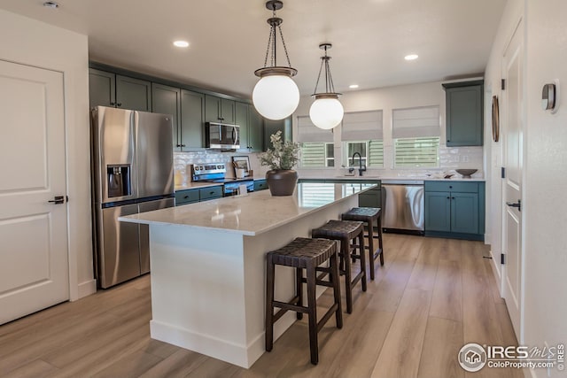 kitchen featuring a kitchen island, a kitchen breakfast bar, stainless steel appliances, and light wood-type flooring