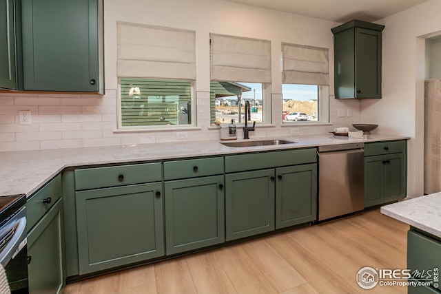 kitchen featuring appliances with stainless steel finishes, green cabinets, and a sink